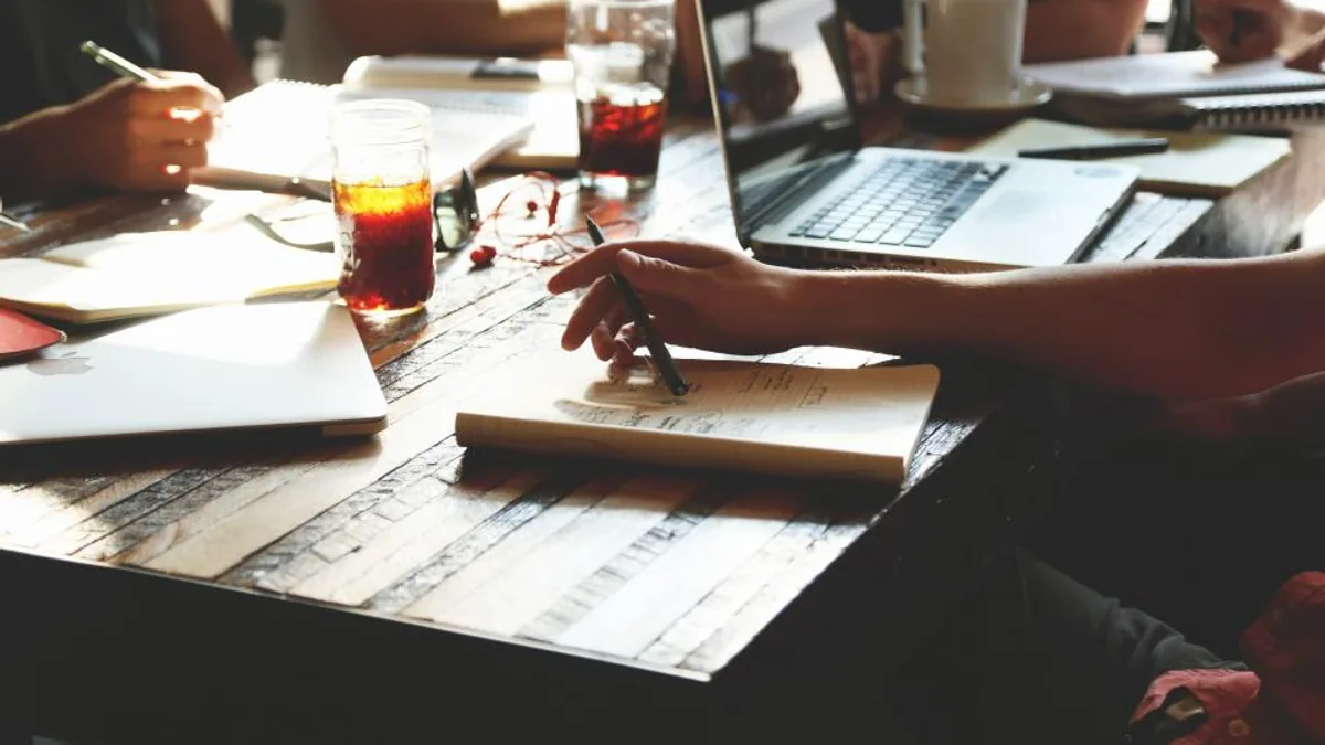 Réunion d'équipe autour d'une table pour définir la stratégie de gestion des avis clients