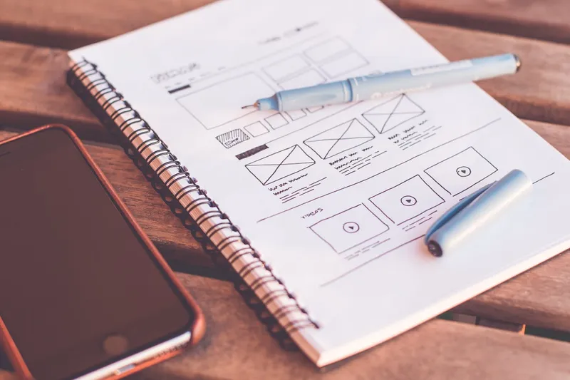 Wireframe UX design esquissé sur un carnet — planification de l'expérience utilisateur