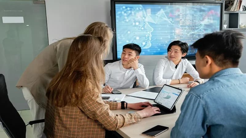 Équipe professionnelle collaborant sur un projet web dans un bureau moderne