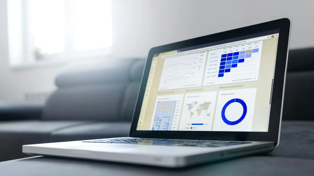 Tableau de bord d'analyse d'audience web sur un ordinateur portable, avec courbes de trafic et répartition des sources