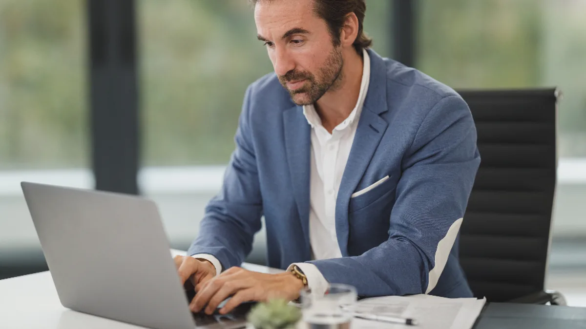 Un dirigeant de PME utilise des outils d'intelligence artificielle sur son ordinateur portable